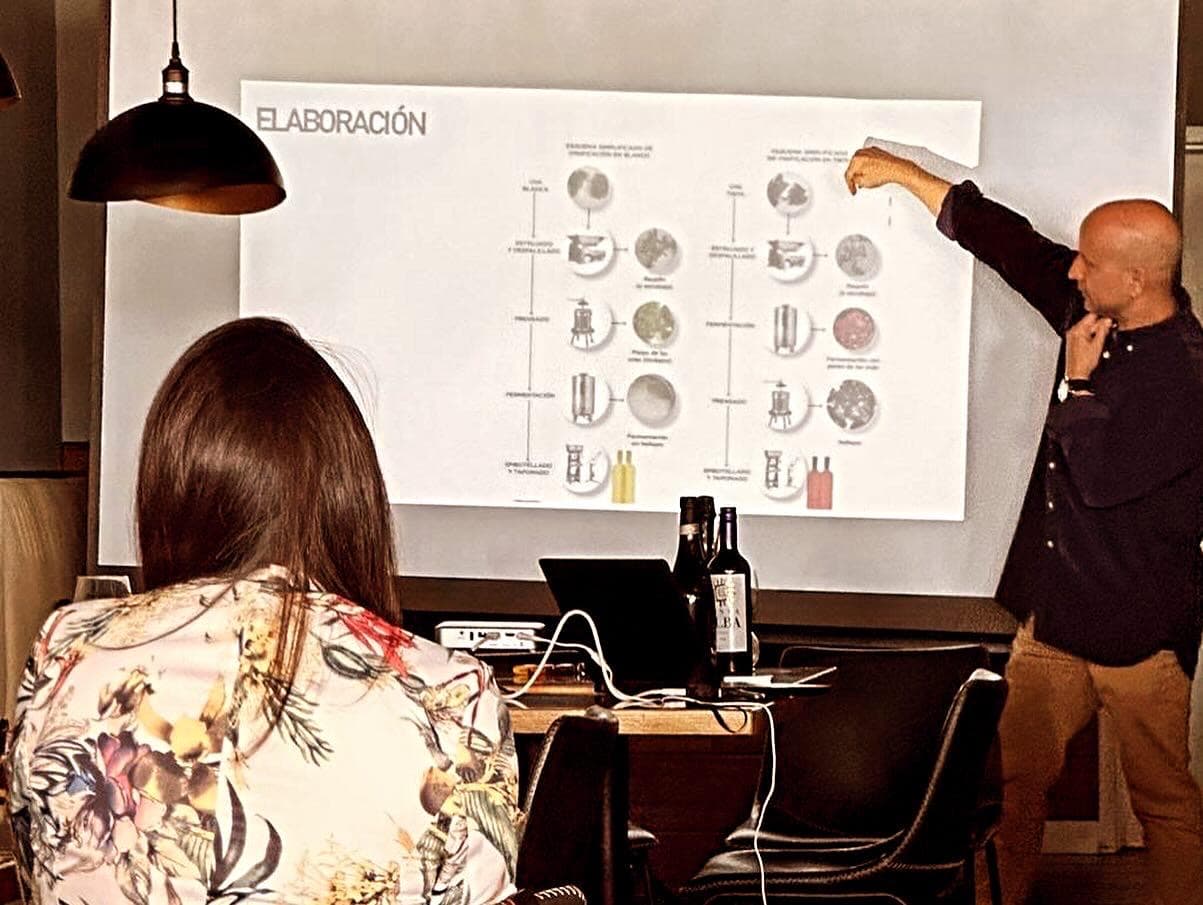 An instructor pointing at a winemaking diagram projected on a screen