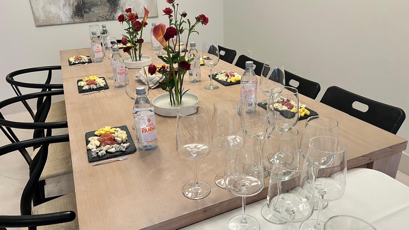 An evening tasting at a long table beside a pool, strung with lights, hosts talking to seated guests