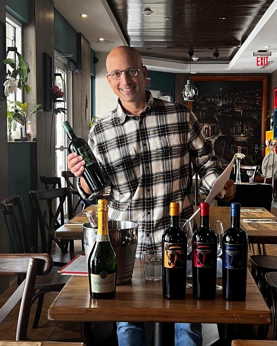 Gustavo Piteo presenting a flight of wines across a restaurant table